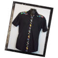 Our Signature Swearing Parrot Hulabilly in black. This shirt is 100% cotton with a contrasting front and back yoke and red pearl snap buttons. Available in our shop.